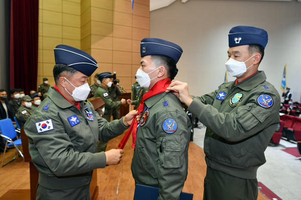사진 = 공군 제1전투비행단은 11월 18일(금) 22-2차 고등비행교육과정 수료식을 거행했다. 수료 조종사가  빨간마후라를 수여받고 있다.(사진 = 상사 서진철)